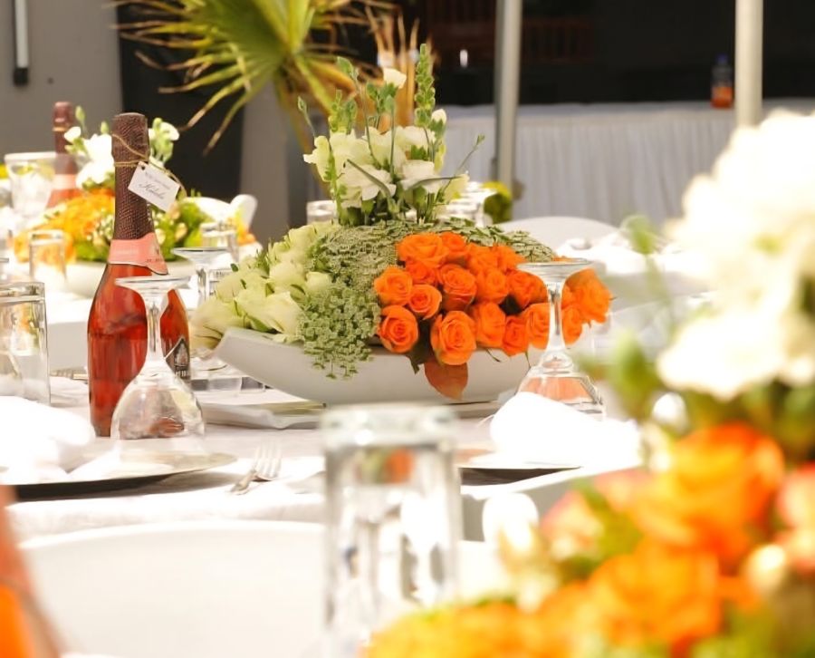 Styled event dinner table with orange and white flowers