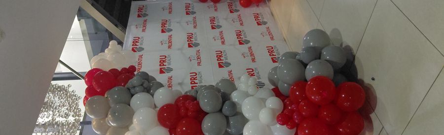 Tall balloon garland beside a branded backdrop